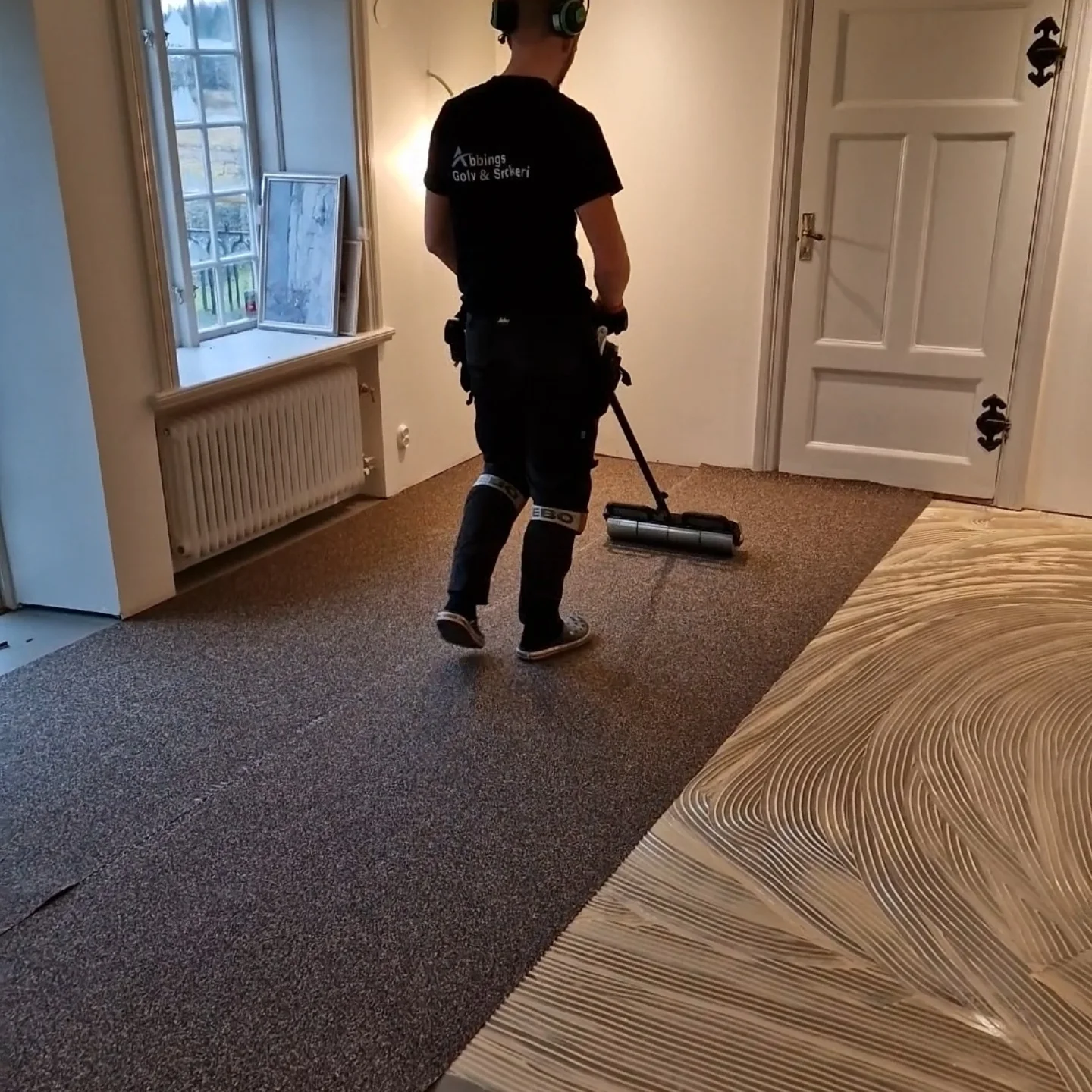Limspridning med tandad spackel innan parketten läggs