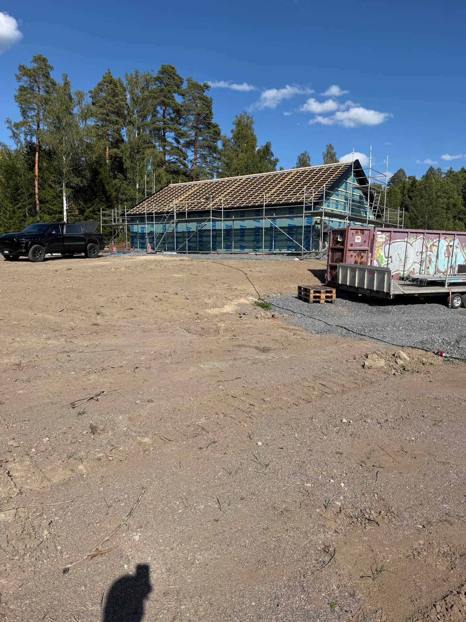 Hus under ombyggnad med ställning och nytt yttertak på plats